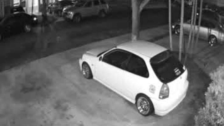 Surveillance camera catches man throwing paver at car windshield